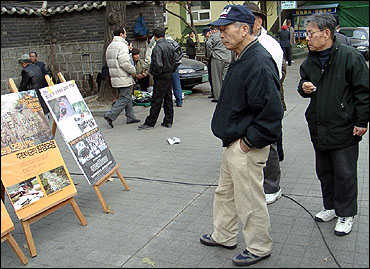 탑골공원에 모인 노인들이 공원정문 앞에 설치된 주한미군 범죄 사진을 바라보고 있다. 